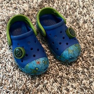 A pair of blue and green crocs size C7 gently used